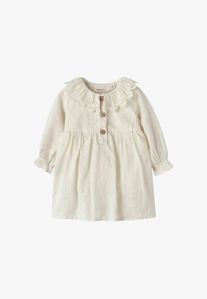 Kremfarvet babykjole med lange ærmer, blondekrave, tre brune knapper foran og delikat blomstret broderi.