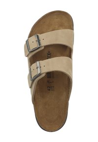Sandalo in suede beige con due cinturini regolabili in metallo e suola marrone sagomata con marcature della taglia e del marchio ben visibili.