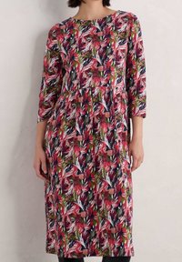 Sukienka w kwiatowy print w odcieniach czerwieni, różu i zieleni na ciemnym tle. Posiada rękawy o długości trzech ćwiartek oraz marszczoną talię.