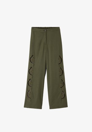 Pantalon large vert olive avec fermeture par boutons et motifs floraux découpés symétriques le long des deux jambes extérieures.