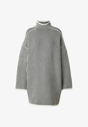 Gestreifter Rollkragenpullover in Schwarz und Weiß. Verfügt über eine lockere Passform, gerippte Textur und weite Ärmel. Akzente sind ein hoher Kragen.