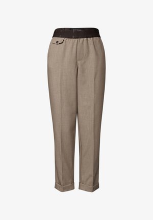 Beige tapered trousers with cuffed hems, a black elastic waistband, and a small buttoned flap pocket on the right side.