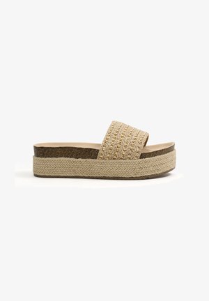 Sandalia tipo slide beige con plataforma, suela trenzada, entresuela de corcho y adornos de cuentas doradas en la tira ancha de tela.
