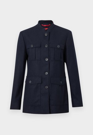 Marineblaue Jacke aus strukturiertem Stoff, mit Stehkragen, sechs Fronttaschen und Knöpfen entlang der Frontschließung.