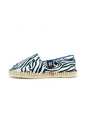 Espadrille à imprimé zèbre avec un dessus en toile noir et blanc, présentant une semelle en jute tissée et une doublure intérieure bleue.