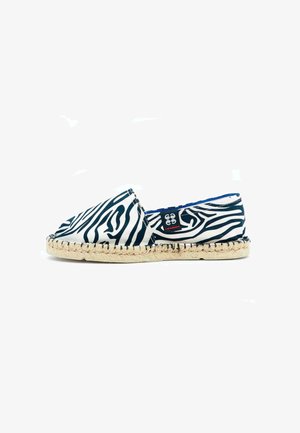 Espadrille à imprimé zèbre avec un dessus en toile noir et blanc, présentant une semelle en jute tissée et une doublure intérieure bleue.
