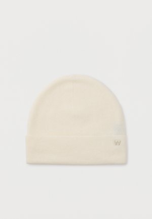 Crème-kleurige gebreide beanie met een opgerolde rand en een klein geborduurd "W" logo aan de onderzijde rechts.