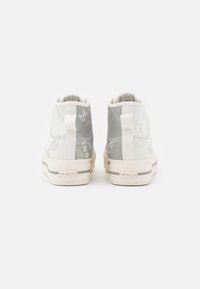 Pair of white and gray high-top Adidas Nizza sneakers shown from the back with fabric pull tabs and logo on the heel.