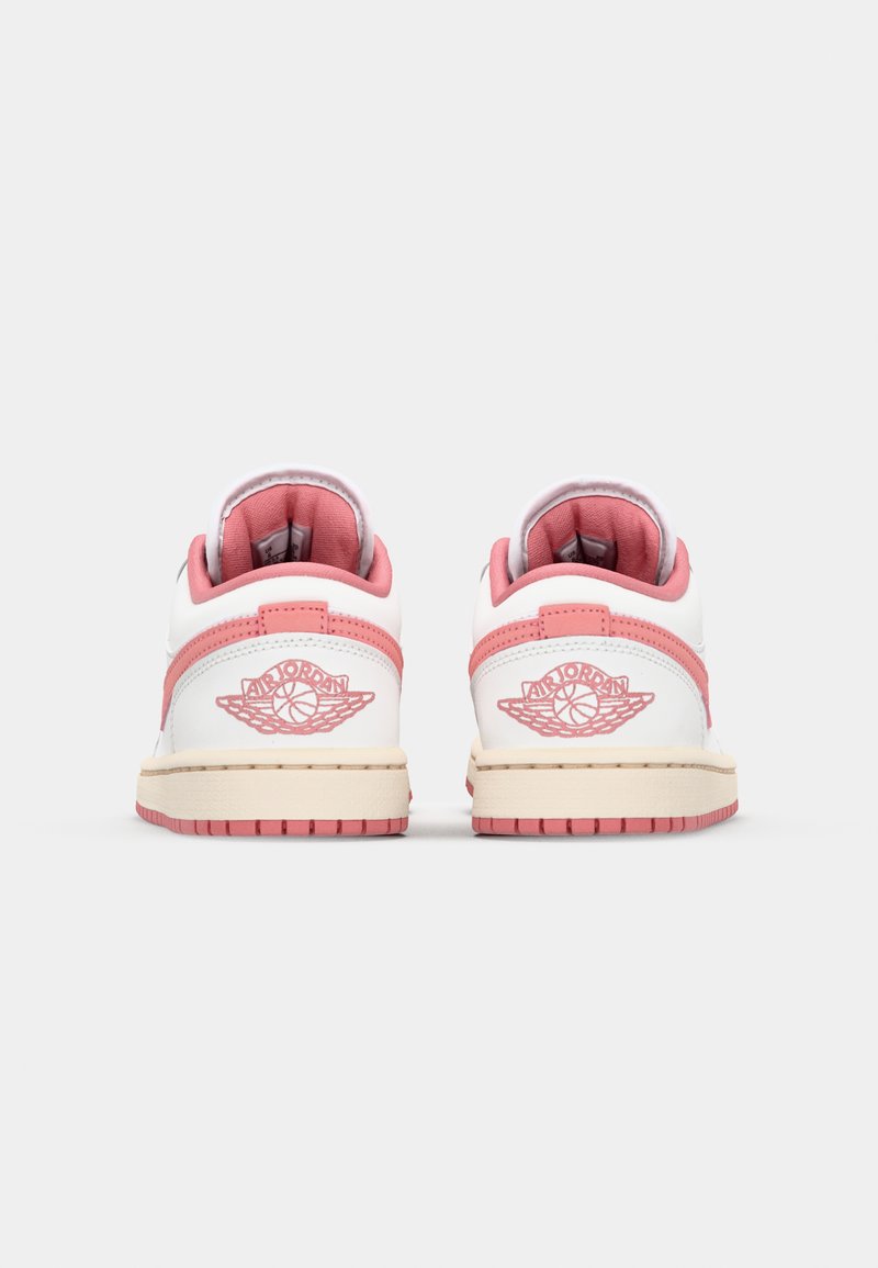 Baskets basses blanches et roses au toucher doux, avec un logo sur le talon, des coutures contrastantes et une semelle en caoutchouc.