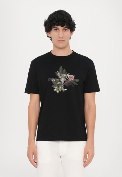 Fekete pamut póló, amelyen levél- és gyümölcsgrafika látható, középen az "EMPORIO ARMANI" felirattal. Rövid ujjú, kerek nyakú.
