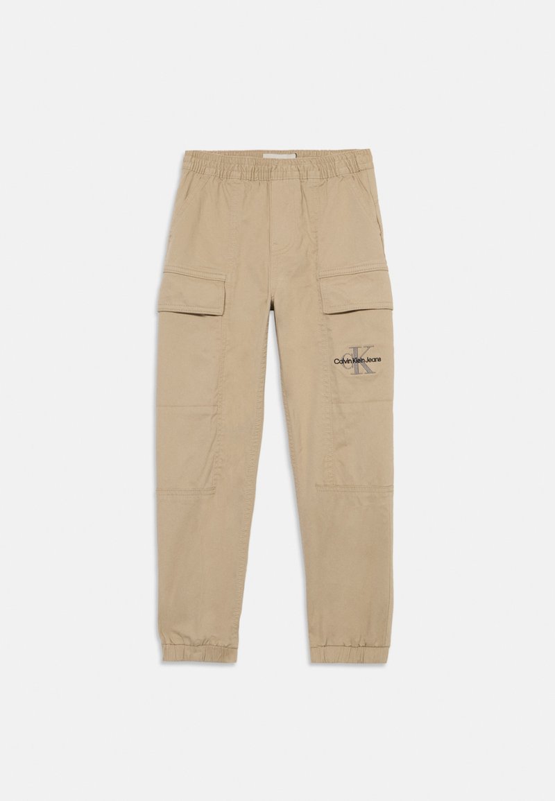 Beige cargo-housut, jotka on valmistettu puuvillasta, joissa on joustava vyötärö, useita taskuja ja logo-aksentti vasemmassa reidessä.