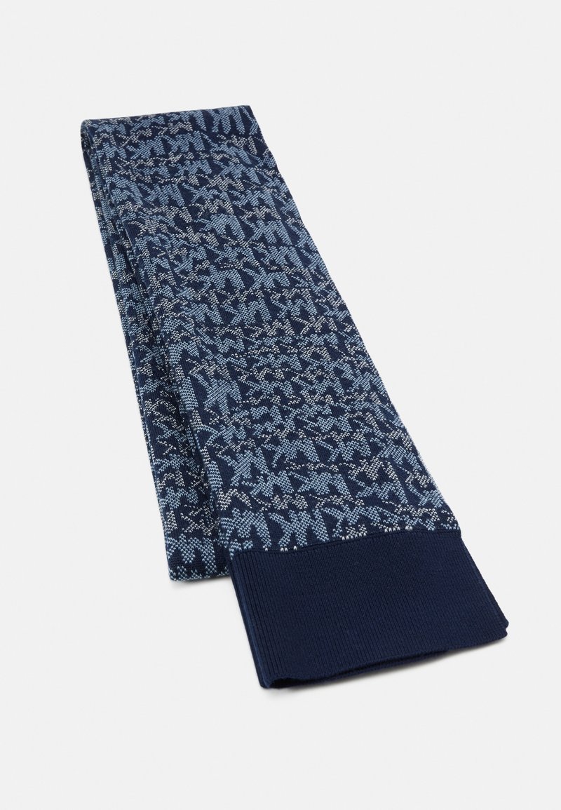 Écharpe tricotée bleu marine à motifs avec des formes géométriques bleu clair et des extrémités côtelées unies, pliée sur fond blanc.