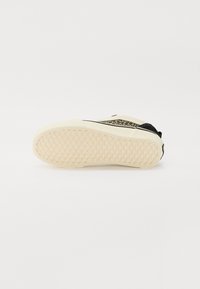 Sort sneakers med leopardmønstrede accenter, en struktureret beige gummisål og en glat overdel. Har et slankt design uden synlige snørebånd.