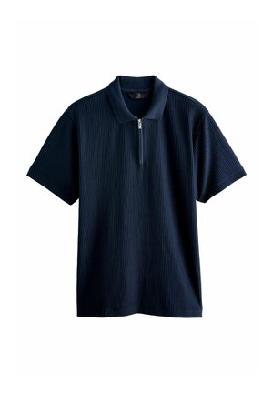 Tengeri kék poloing bordás textúrával, rövid ujjakkal és cipzáros gallérral. Puha anyagból készült, a kényelem és a légáteresztő képesség érdekében.