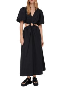 Musthave mustrühmaga musta maksiekleiding, millel on puhvvarrukad, sügav V-kaelus, lõikega vöökoht, millel on ümmargune aksessuaar, ja kogutud rind. Sile kangatextuur.