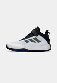 Bílé sportovní tenisky s černými a modrými akcenty, síťovaným svrškem, bezpečnostním popruhem a strukturovanou gumovou podrážkou, navržené pro výkon a pohodlí.