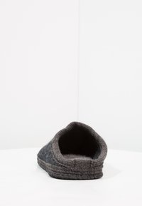 Grijze wollen pantoffel met een zachte, gestructureerde afwerking, ronde neus en gestikte randen. Heeft een gezellige, lage snit voor extra comfort.