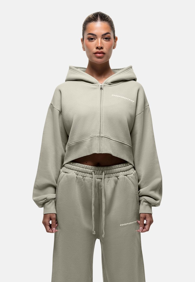 Felpa con zip accorciata e pantaloni abbinati in morbido tessuto verde chiaro. Presenta logo, vestibilità rilassata e cintura elastica.