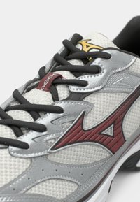 Light gray athletic shoe with mesh material, silver accents, maroon logo, black laces, and textured details along the sides.