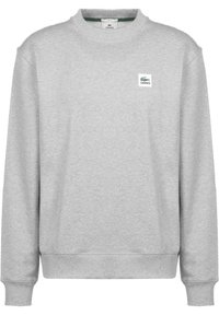Felpa grigia con maniche lunghe, scollo a girocollo a coste e polsini elastici. Presenta una piccola toppa con il logo Lacoste sul davanti. Texture morbida.