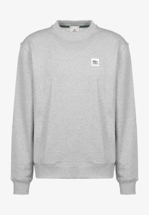 Grijze trui met lange mouwen, geribde ronde halslijn en elastische manchetten. Voorzien van een klein Lacoste-logo op de voorkant. Zachte textuur.