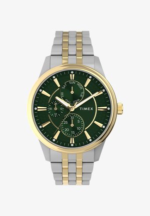 Timex watch with a green dial, gold and silver stainless steel case, three sub-dials, gold hour markers, and a textured background.