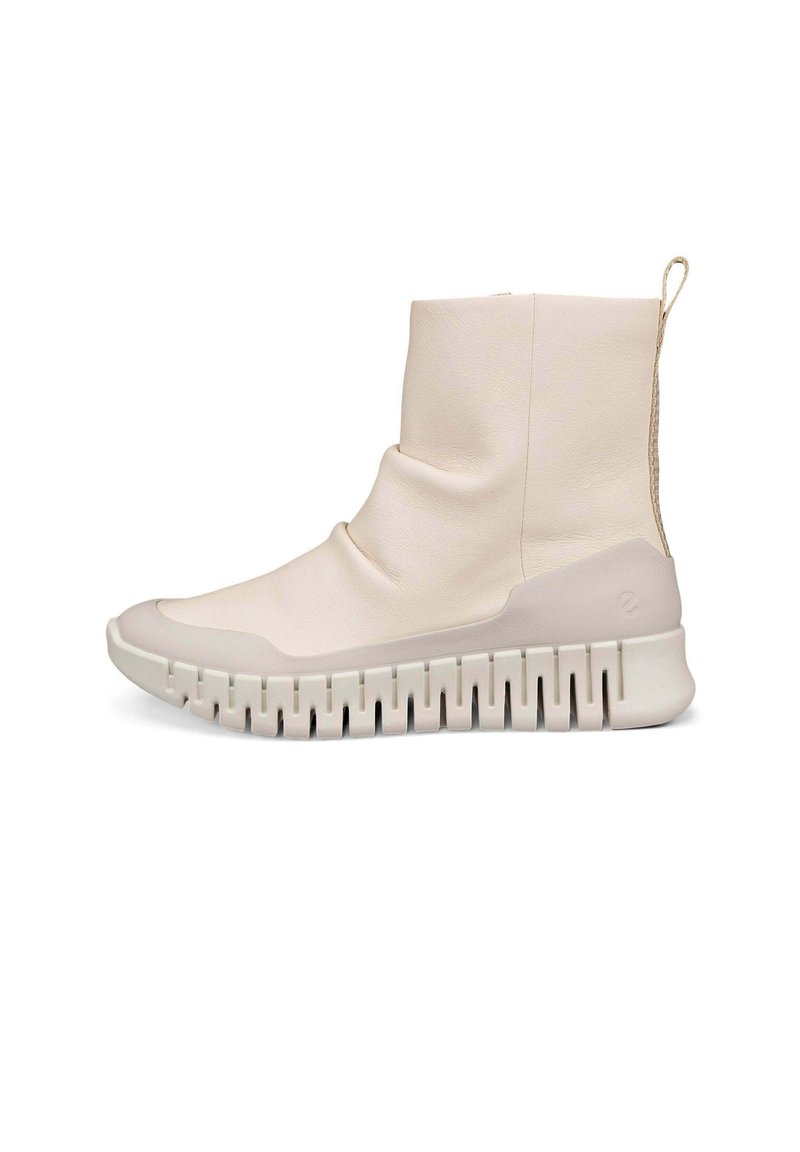 Stivaletti alla caviglia beige chiaro in pelle liscia, con una parte superiore morbida e una spessa suola in gomma bianca con un motivo scanalato.