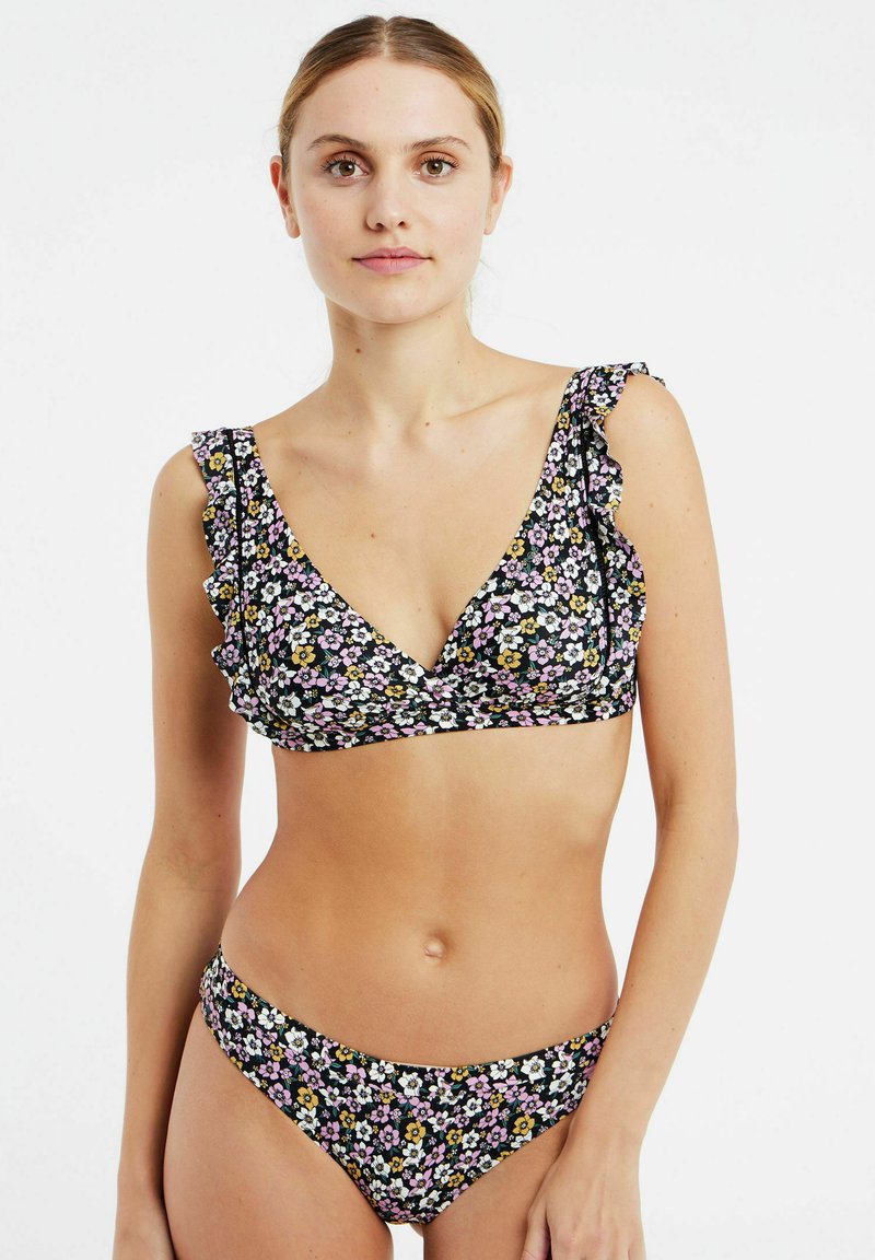 Conjunto de bikini floral con un fondo negro. La parte superior presenta detalles de volantes, un escote en V pronunciado y un estampado floral en tonos rosa, blanco y amarillo.