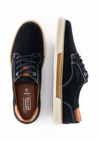 Granatowe trampki z płóciennym wierzchem, brązowymi skórzanymi akcentami, białą gumową podeszwą i białym ściegiem. Sznurowany krój.