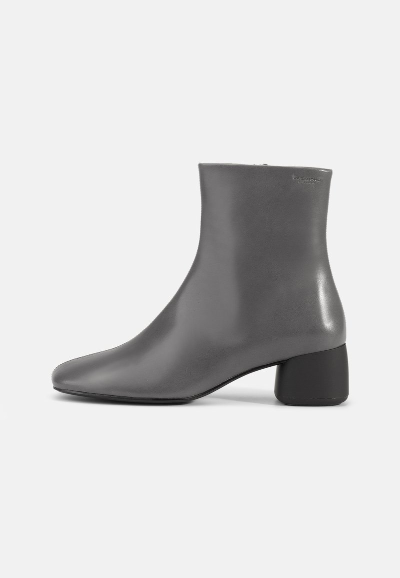 Botín de cuero gris con un diseño elegante, punta afilada y un tacón corto tipo bloque. Textura suave con un mínimo de marcas en el costado.