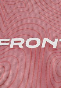 Tessuto rosso strutturato con un motivo sottile e il testo bianco "FRONT" ben visibile. Il materiale appare leggero e traspirante.