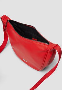 Czerwona skórzana torebka na ramię z górnym zamkiem, teksturowanym wykończeniem i kontrastowym czerwonym paskiem. Posiada wewnętrzne kieszenie do organizacji.