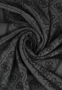 Tissu noir à motif avec un design géométrique et une finition brillante. Le matériau est doux et lisse, mettant en valeur son apparence texturée.