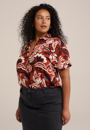 Rotes Blumen-Hemd mit weißen und schwarzen Mustern, kurzärmlig, kombiniert mit einem dunklen Jeansrock. Glatte Textur.