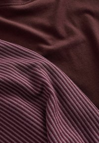 Baumwollmischgewebe in dunkelmaroon und gestreift in Burgunderrot. Weiche Textur mit glatter Oberfläche, die abwechselnd helle und dunkle Streifen aufweist.