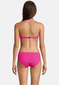 Bikini rose à côtes avec un haut à nouer derrière le cou et un bas taille haute. Texture lisse et bordures à contraste.