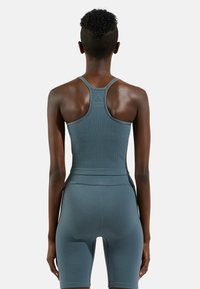 Ribbed dark gray athletic tank top with a racerback design, paired with matching fitted shorts. Textured fabric, smooth accent lines.