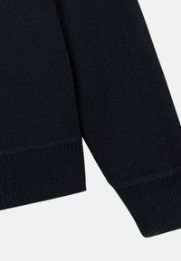 Pull en maille bleu marine foncé avec des poignets et un ourlet côtelés. Texture douce avec un design simple, présentant des coutures régulières et sans motifs visibles.