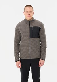 Fleece jacket in brown with a textured pattern. Features a black zippered chest pocket and zip front, high collar, and long sleeves.