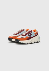 Sport sneakers featuring a mix of blue, red, orange, and cream suede and mesh upper, with a chunky white and black rubber sole.