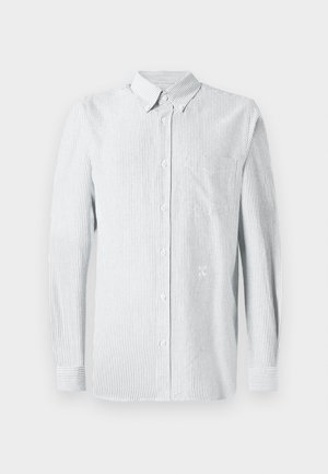 Camisa de manga larga a rayas en azul claro y blanco, con cuello abotonado, bolsillo frontal y un logo sutil en el pecho.