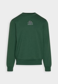 Sweatshirt vert avec un col rond, des manches longues et des poignets côtelés. Sur le devant, logo "Lacoste" brodé et emblème du crocodile.