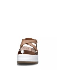 Sandal in pelle marrone con accenti intrecciati, punta aperta, design a fascia incrociata e suola piatta bianca con scanalature.