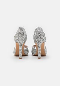 Silberne Glitzer-High Heels mit spitzem Zehenbereich, dünnem Stiletto-Absatz und glattem Innenleben. Die Absatzhöhe beträgt etwa 10 cm.