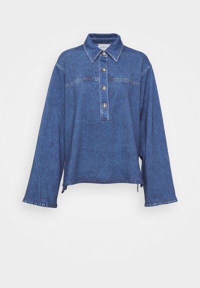 Denim shirt in dark blue with long sleeves, collared neck, five-button placket, and subtle faded texture. Features split side hem.