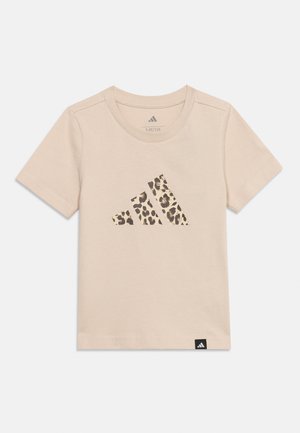 Lyse beige t-shirt med korte ærmer med leopardprint Adidas-logo foran og lille sort Adidas-mærke i bunden af sømmen.