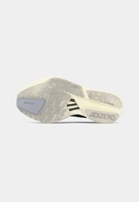 Sål af en løbesko med tekstureret greb, Continental-logo, "ADIZERO" og "LIGHTTRAXION" branding, mod en ensfarvet hvid baggrund.