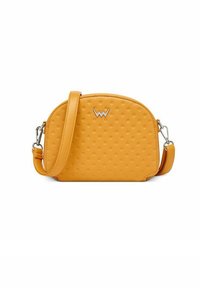 Yellow leather crossbody bag with a rounded shape, embossed dot pattern, silver hardware, and an adjustable strap. Logo displayed on the front.