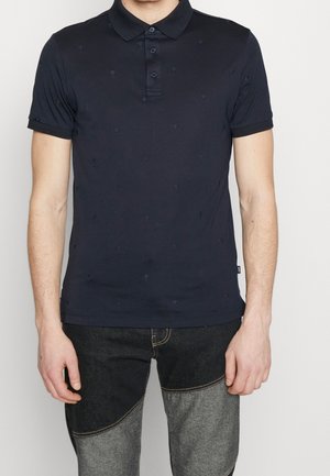 Polo bleu marine en coton à manches courtes, avec un motif brodé subtil et une patte à trois boutons.