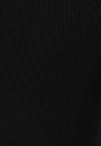 Schwarzer, gerippter Stoff mit vertikalen Linien, der eine glatte Textur und ein leicht dehnbares Design aufweist. Das Material scheint leicht zu sein.